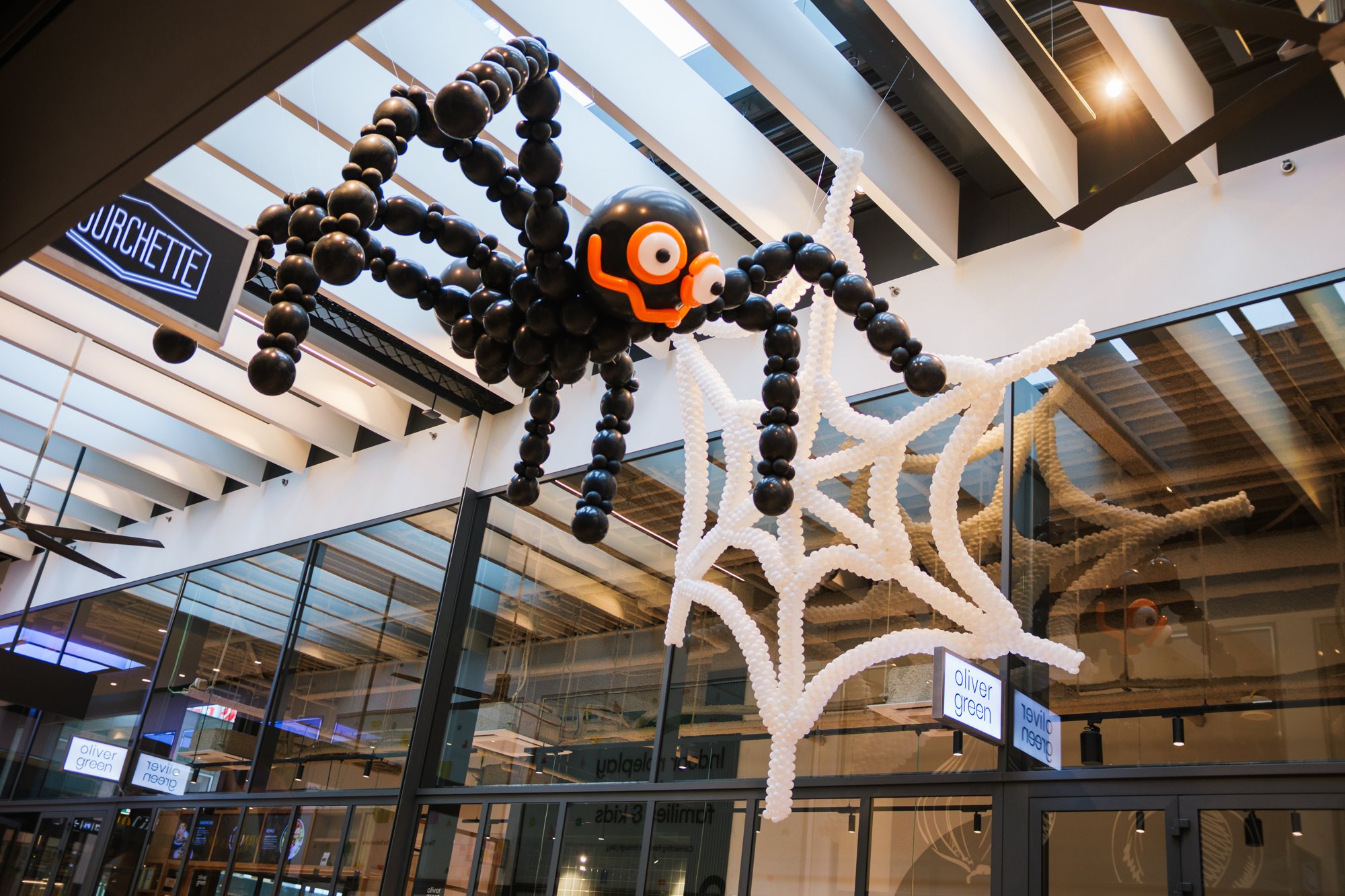 Black balloon spider with white web at Gelderlandplein (2026) — Design: Bidou, web Compagnie Les Allumeurs — Photo: zestien:negen
