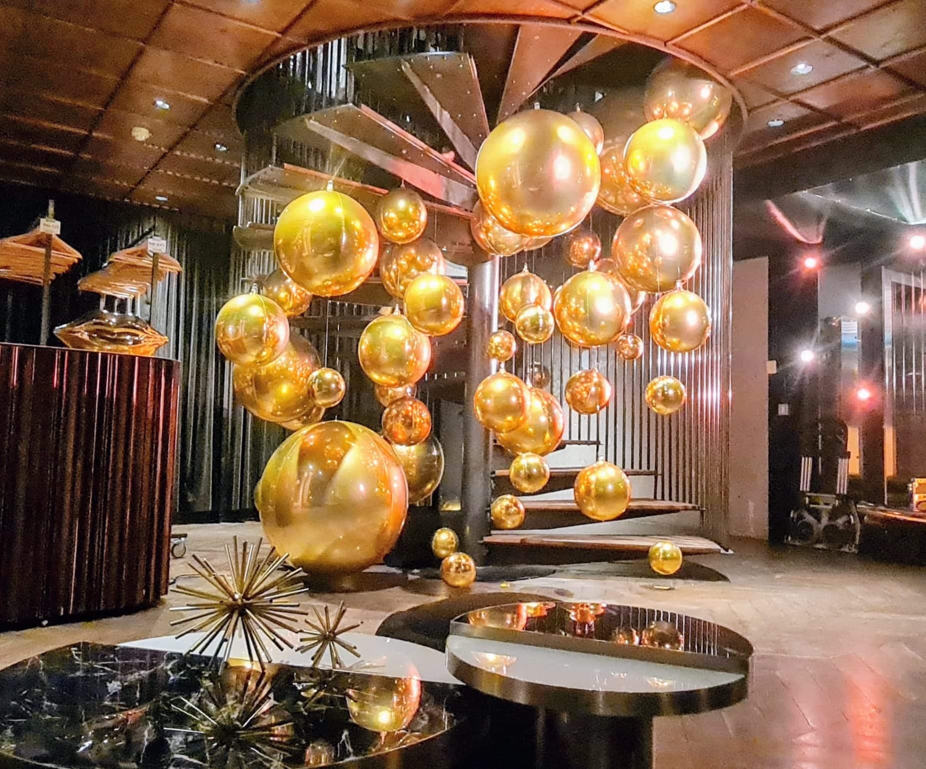 Golden balloon installation along the spiral staircase at A'DAM Toren Amsterdam — Moët & Chandon brand activation by Out of Thin Air via 8 The Agency