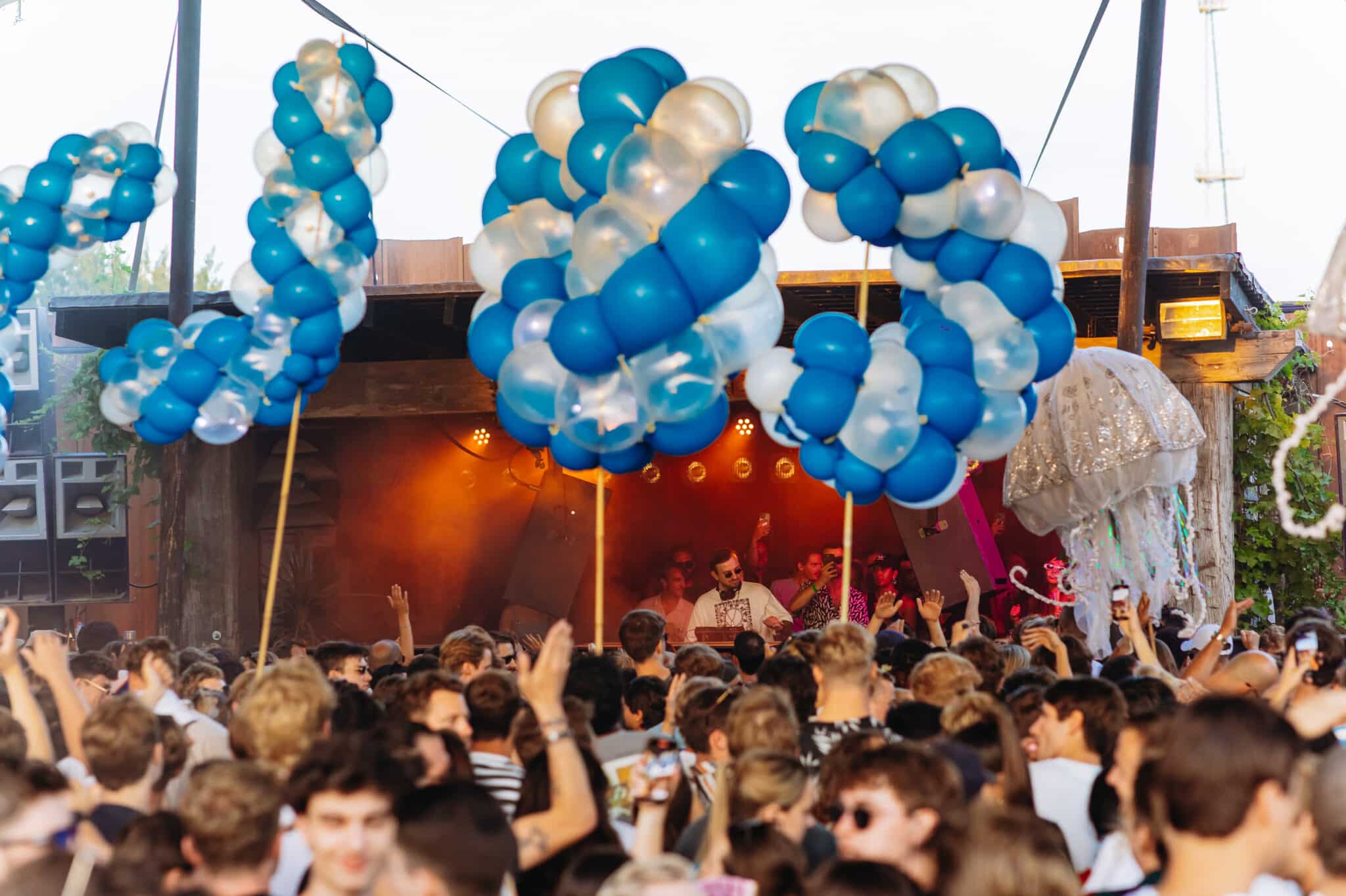 Giant spiral balloon letters spelling COLYN above dancing crowd at Thuishaven Amsterdam — Spellbound — Out of Thin Air